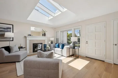 a living room with furniture a fireplace and a large window