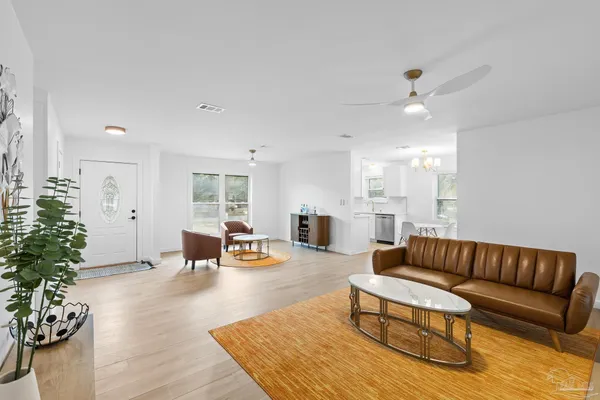 a living room with furniture kitchen view and a potted plant