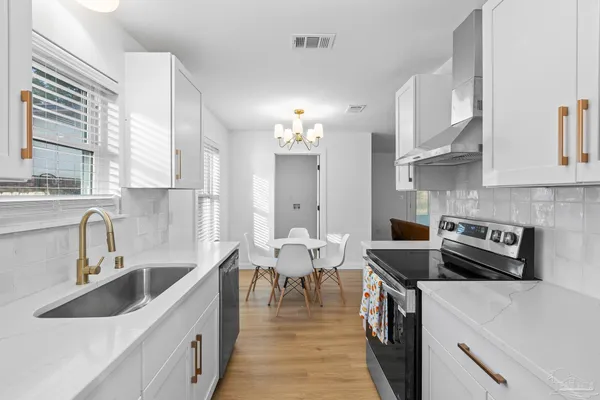 a kitchen with a stove sink and cabinets