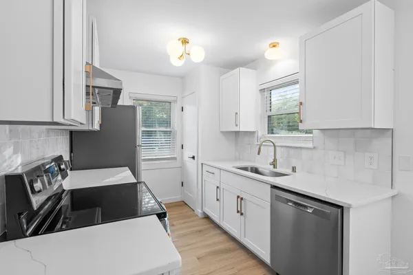 a kitchen with a sink dishwasher a stove and a refrigerator with wooden floor