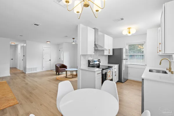 a kitchen with refrigerator a sink and chairs