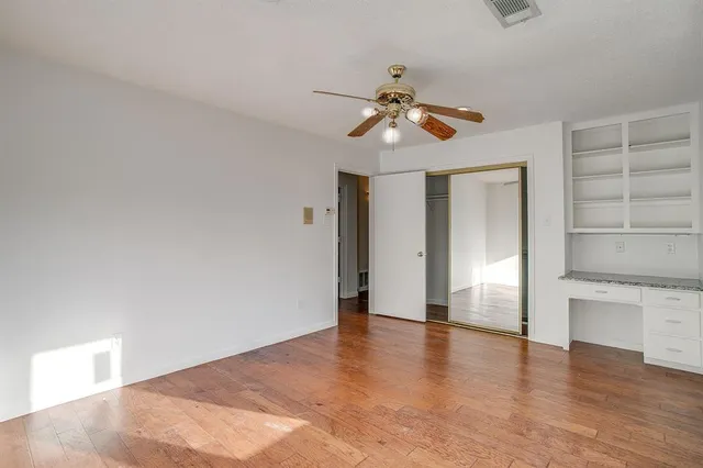 a view of room with hardwood floor and ceiling fan