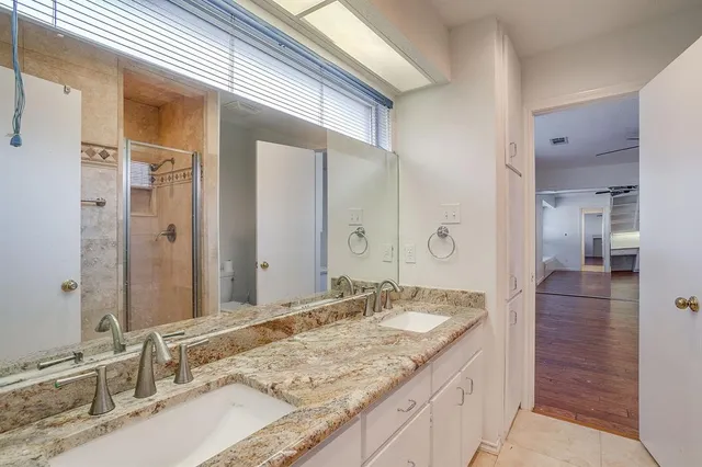 a bathroom with a granite countertop sink and a mirror