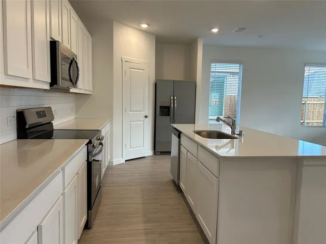 a kitchen with a sink a microwave and cabinets