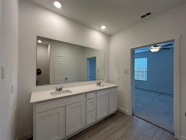 a view of an empty room with a chandelier fan