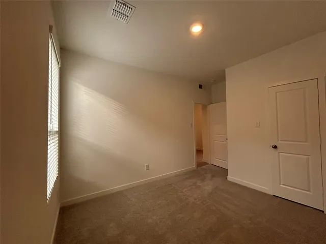 a living room with couches and kitchen view with wooden floor
