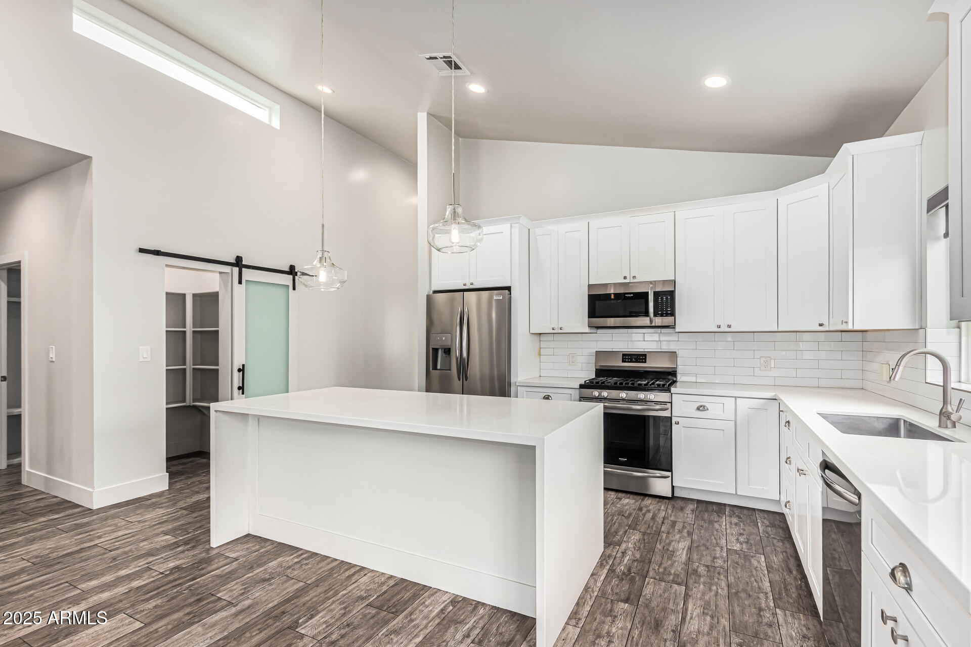 1005 East Weldon Avenue Phoenix, AZ 85014 - Photo 5 of 21 a kitchen with stainless steel appliances granite countertop a sink a stove a refrigerator and white cabinets with wooden floor
