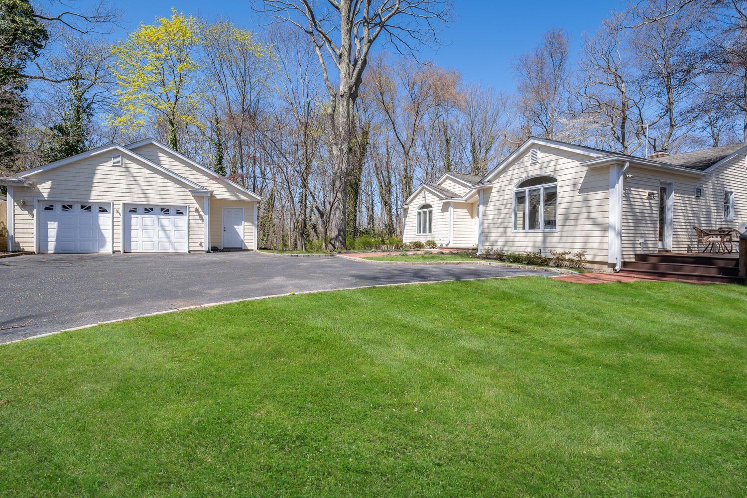 1 A Carnegie Avenue Cold Spring Harbor, NY 11724 - Photo 1 of 1 a front view of a house with a garden and trees