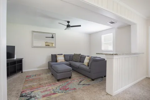 a living room with furniture and a wooden floor