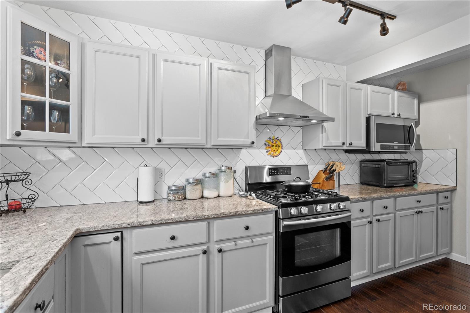 2212 Hyacinth Road Littleton, CO 80129 - Photo 14 of 44 a kitchen with stainless steel appliances granite countertop a stove a sink dishwasher and a microwave oven on the kitchen countertops