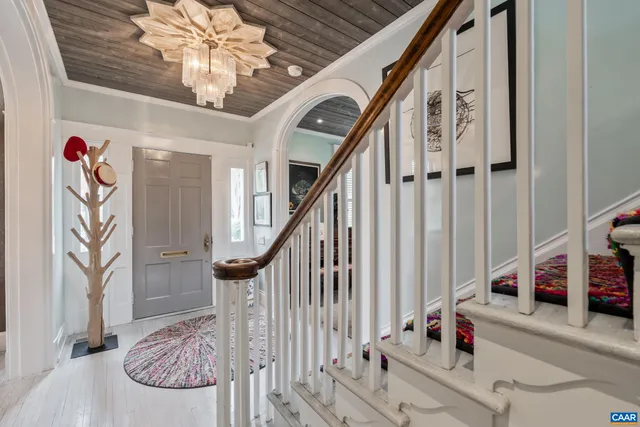 a view of hall way with furniture and paintings on the wall