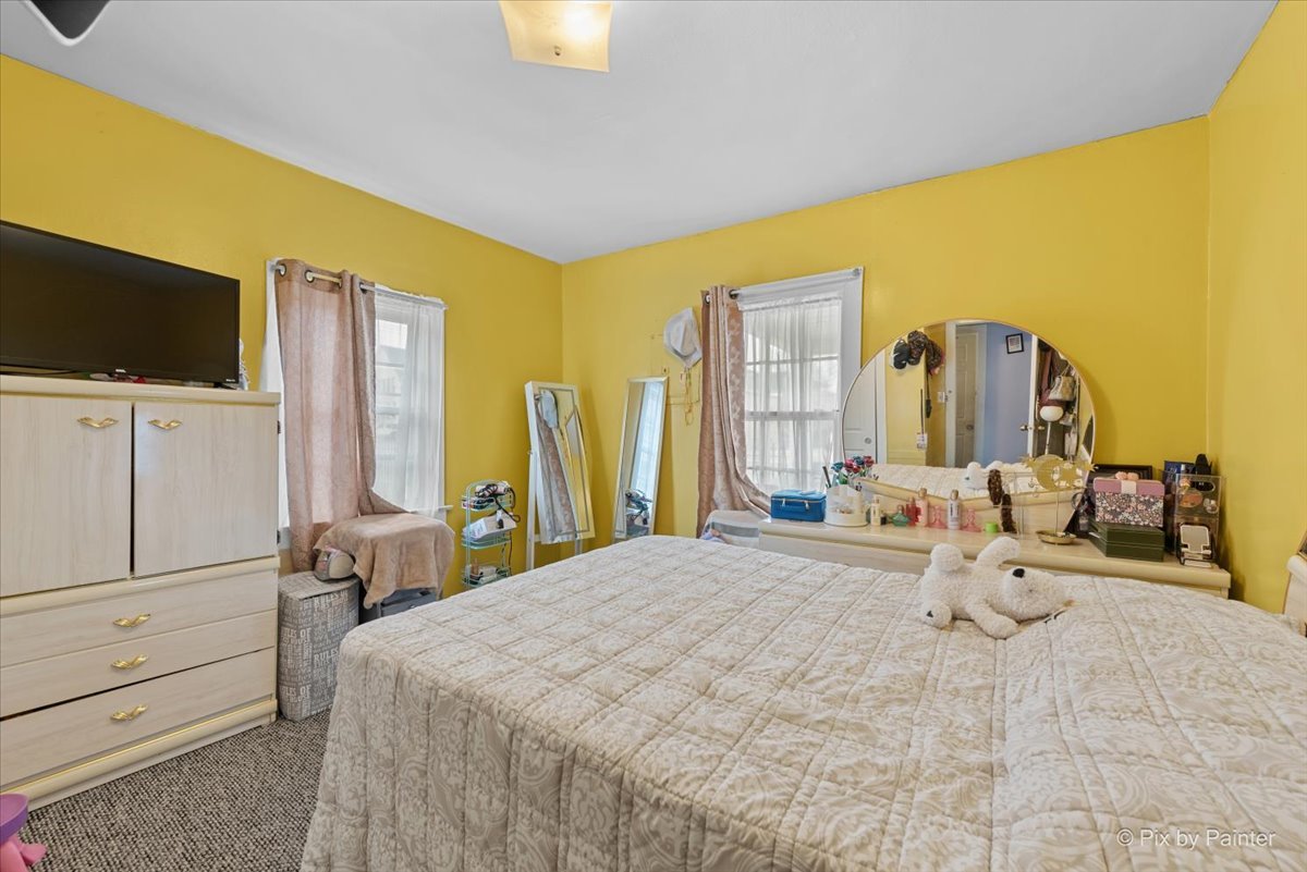 58 South Geneva Street Elgin, IL 60120 - Photo 8 of 24 a bedroom with a bed a flat screen tv and dresser
