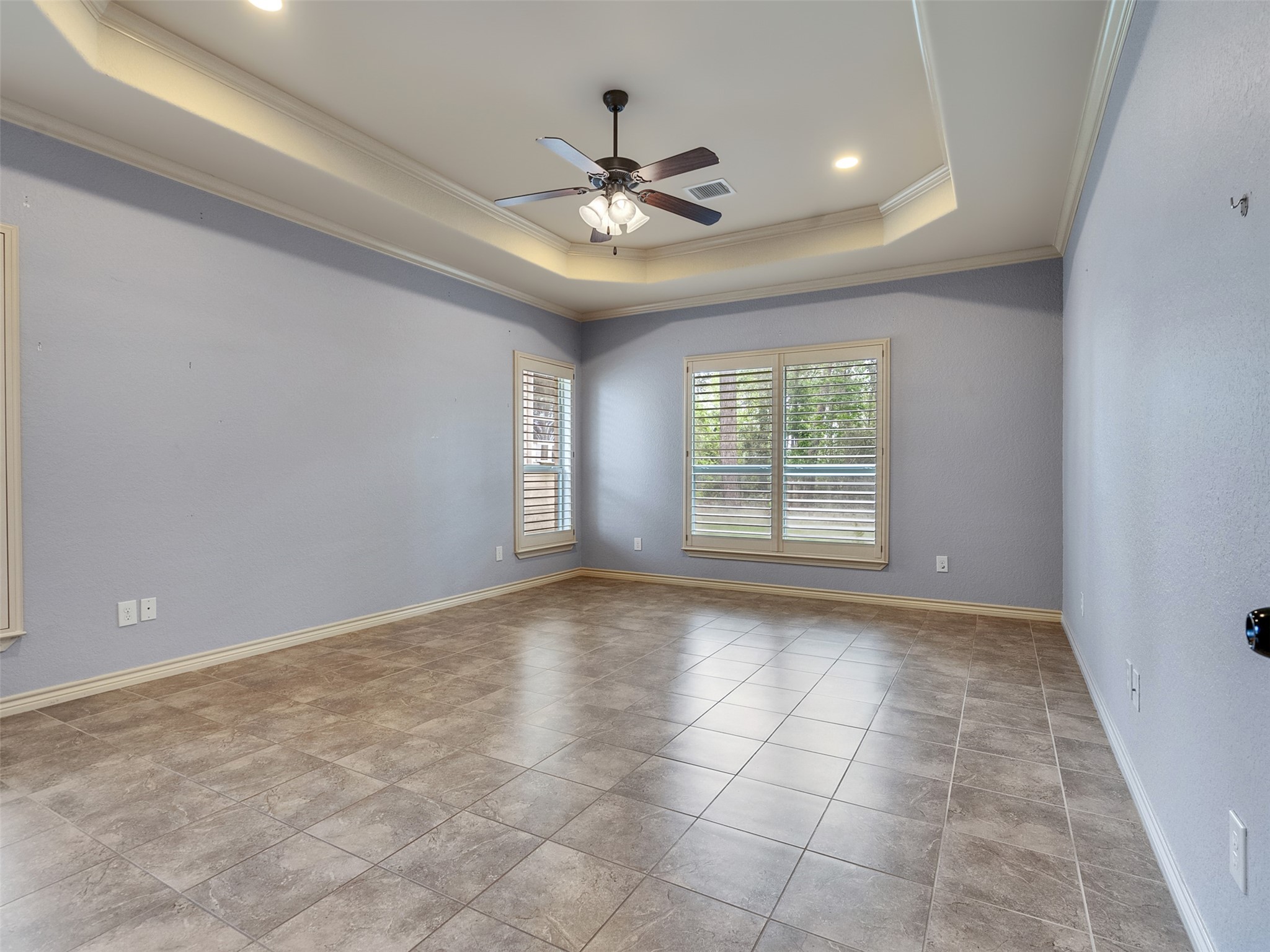 18005 Cindy Lane Conroe, TX 77302 - Photo 28 of 49 This spacious room features a tray ceiling with recessed lighting. Large windows with plantation shutters offer ample natural light.