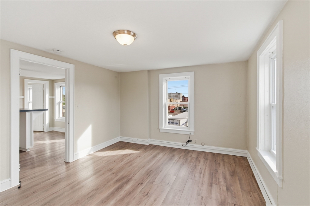 293 Clemente Street, Unit 3R Holyoke, MA 01040 - Photo 8 of 14 an empty room with wooden floor and windows