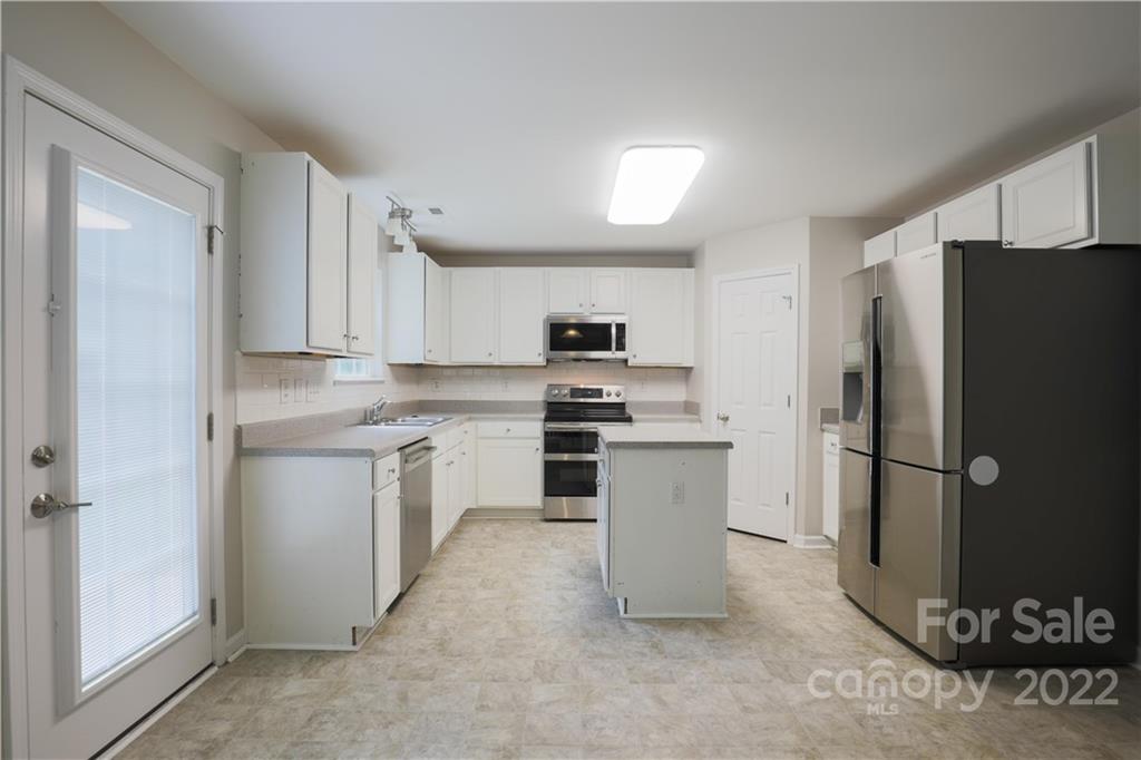 328 Wellridge Drive Fort Mill, SC 29708 - Photo 5 of 23 a kitchen with granite countertop white cabinets and refrigerator