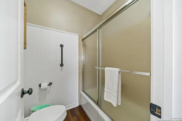 a bathroom with a granite countertop shower and a toilet