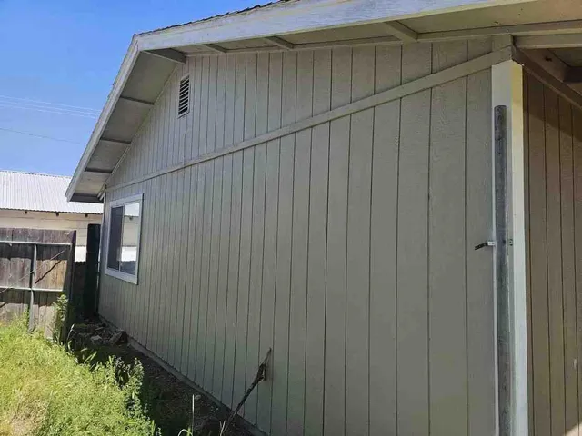 a view of a house with backyard and wooden fence