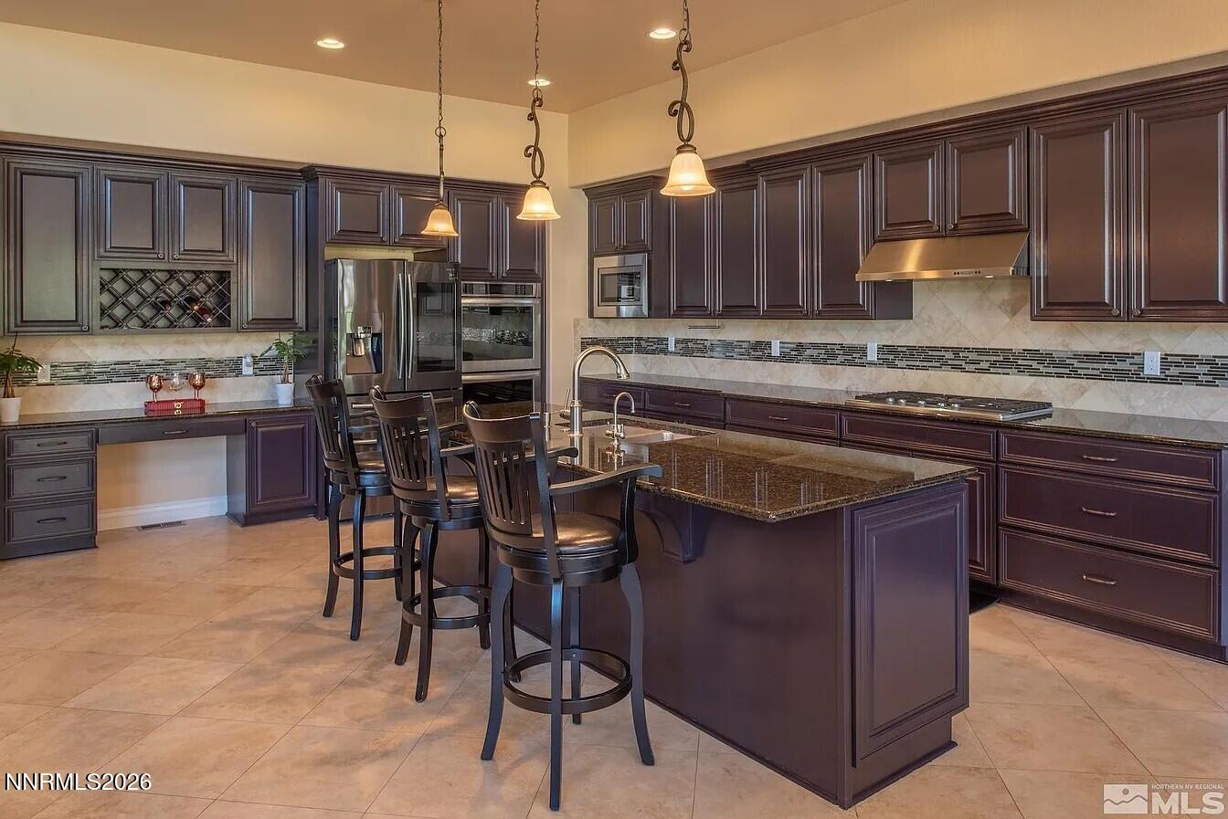 3945 Aspen Reno, NV 89511 - Photo 6 of 21 a kitchen with stainless steel appliances granite countertop a stove a refrigerator a sink a dining table and chairs