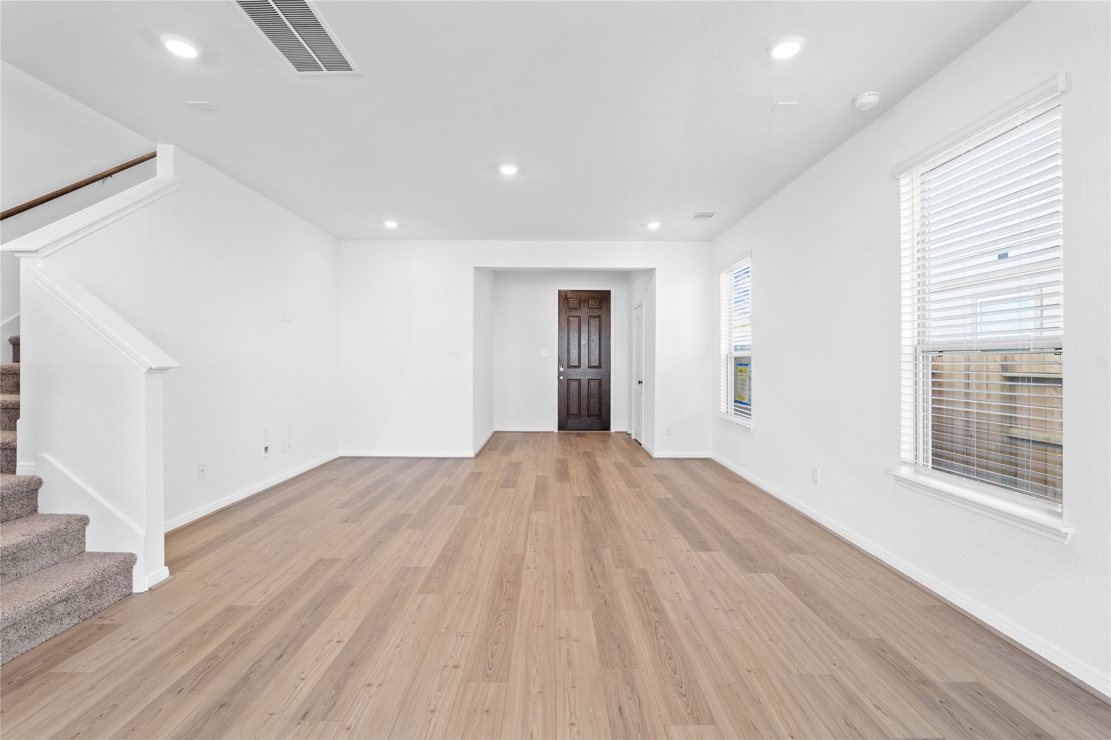 6410 Kentfield Drive Rosharon, TX 77583 - Photo 4 of 25 Bring family and friends together in this beautiful family room! It features high ceilings, recessed lighting, custom paint, stunning Layton Lake vinyl plank flooring in Soft Beige, and large windows that fill the space with natural light all day long.