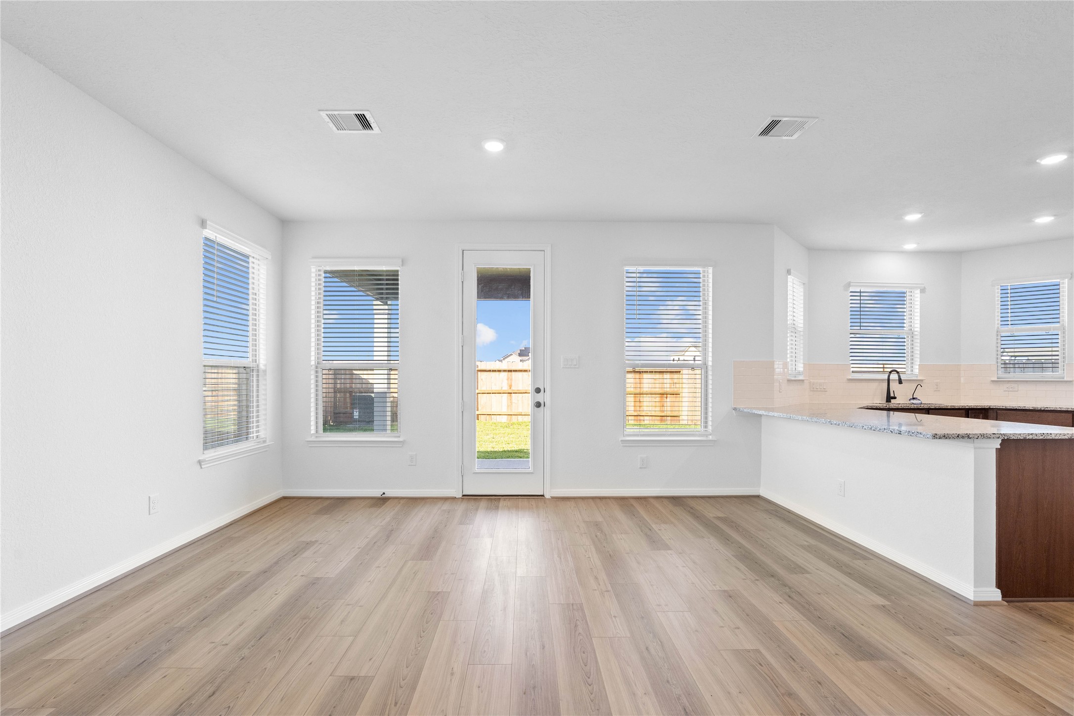 6410 Kentfield Drive Rosharon, TX 77583 - Photo 6 of 25 Create lasting memories around the table with family and friends in this inviting dining room! It showcases high ceilings, large windows with privacy blinds, vinyl plank flooring, and recessed lighting for a warm and welcoming atmosphere.