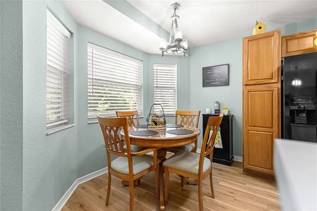 a kitchen with a refrigerator a stove a sink dishwasher and wooden cabinets with wooden floor