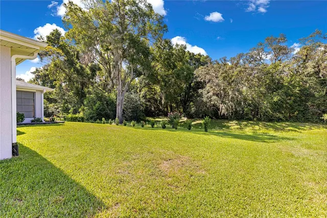 a front view of a house with garden and trees