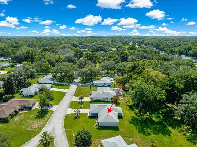 a view of a big house with a big yard and large trees