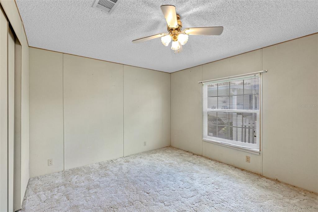 3026 Myakka River Road Tavares, FL 32778 - Photo 17 of 49 an empty room with windows and fan
