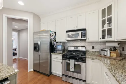 a kitchen with stainless steel appliances granite countertop a refrigerator stove and sink