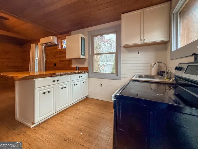a kitchen with granite countertop a sink a stove and cabinets