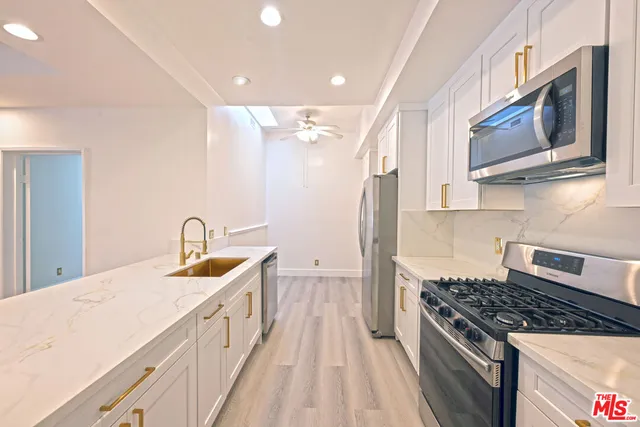 a kitchen with stainless steel appliances granite countertop a sink and a stove