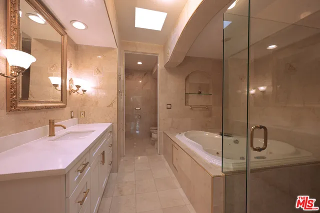 a bathroom with a sink a tub and a mirror