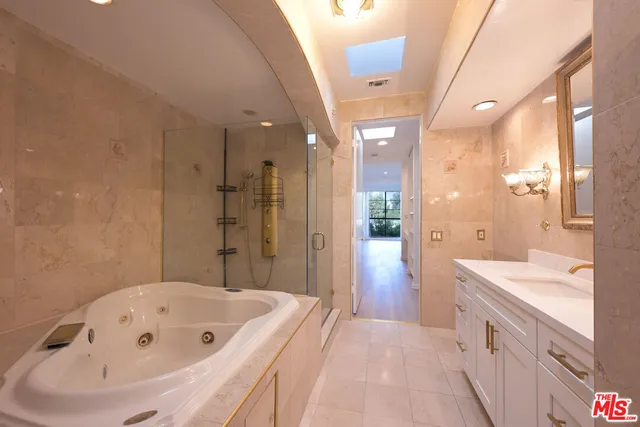 a bathroom with a tub a sink shower and a mirror