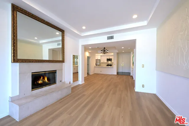 a view of empty room with wooden floor and fireplace