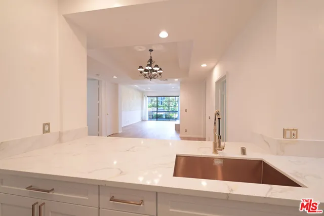 a view of spacious kitchen with granite countertop a sink and dishwasher with wooden floor