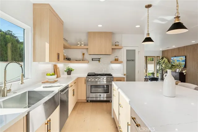 a kitchen with stainless steel appliances granite countertop a sink stove and refrigerator