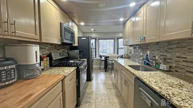 a kitchen with a stove sink and cabinets