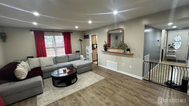 a living room with furniture and a wooden floor