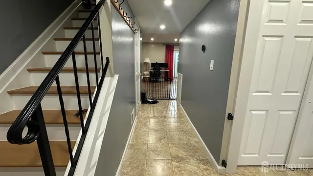 a view of a hallway with wooden floor and staircase