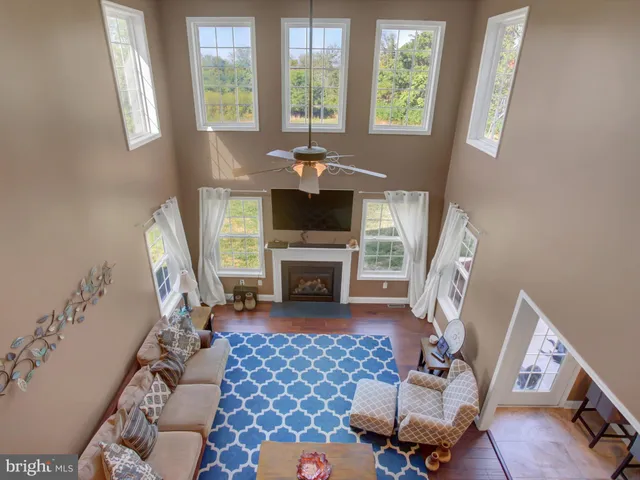 a living room with furniture a fireplace and a floor to ceiling window