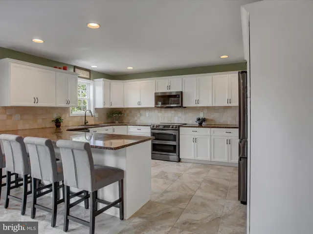 a kitchen with cabinets stainless steel appliances and a window