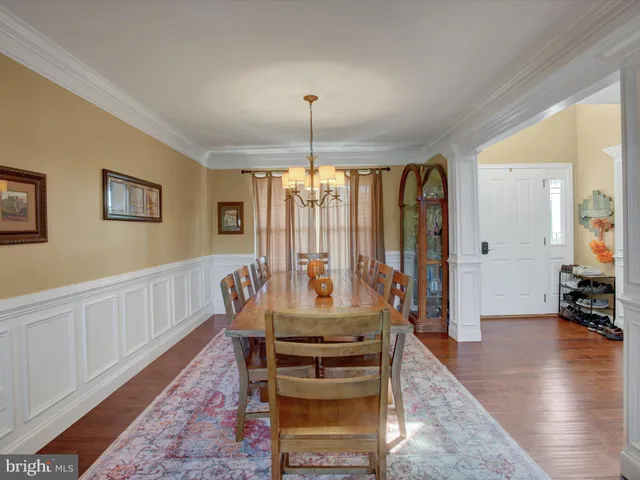 a dining room with furniture window and wooden floor