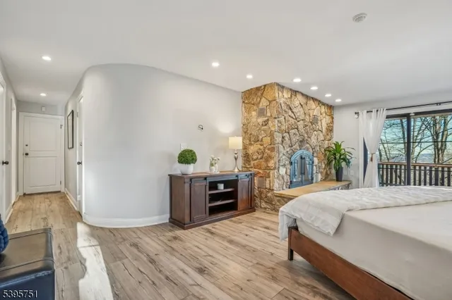 a spacious bedroom with a bed and a dresser with wooden floor