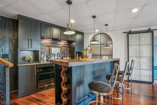 a kitchen with kitchen island a dining table chairs stainless steel appliances and cabinets