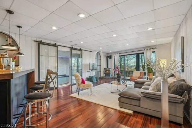 a living room with furniture a flat screen tv and a large window