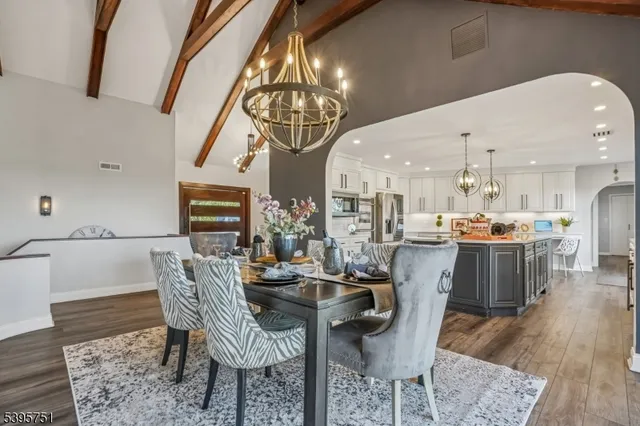 a dining room with furniture a chandelier and wooden floor