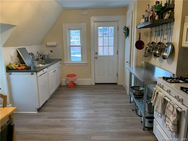 a kitchen with stainless steel appliances granite countertop a stove and a wooden floors