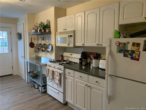 a kitchen with stainless steel appliances granite countertop a refrigerator stove and white cabinets