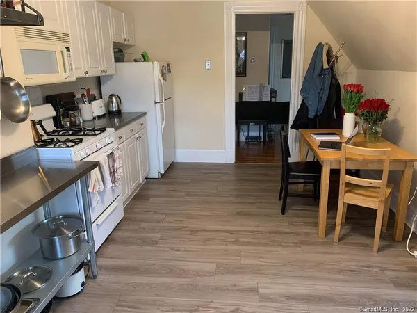 a kitchen with furniture wooden floor and a view of kitchen