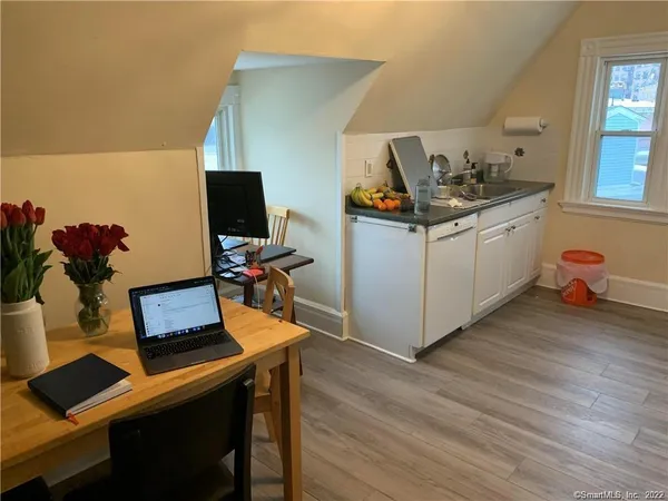 a view of a workspace with furniture and wooden floor